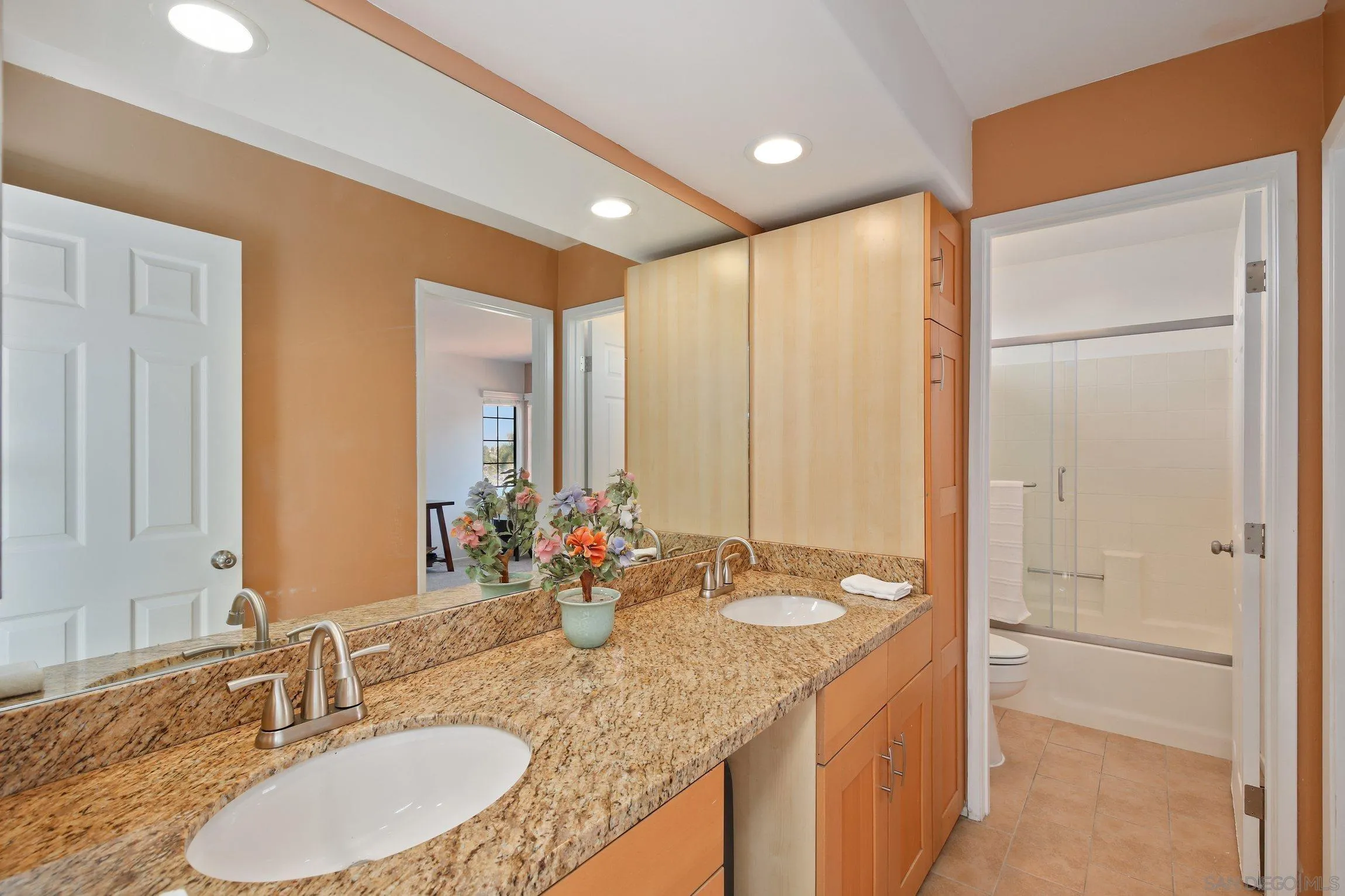 5080 Frazee Road Oceanside, CA 92057 - Photo 26 of 44 a bathroom with a granite countertop sink and a mirror
