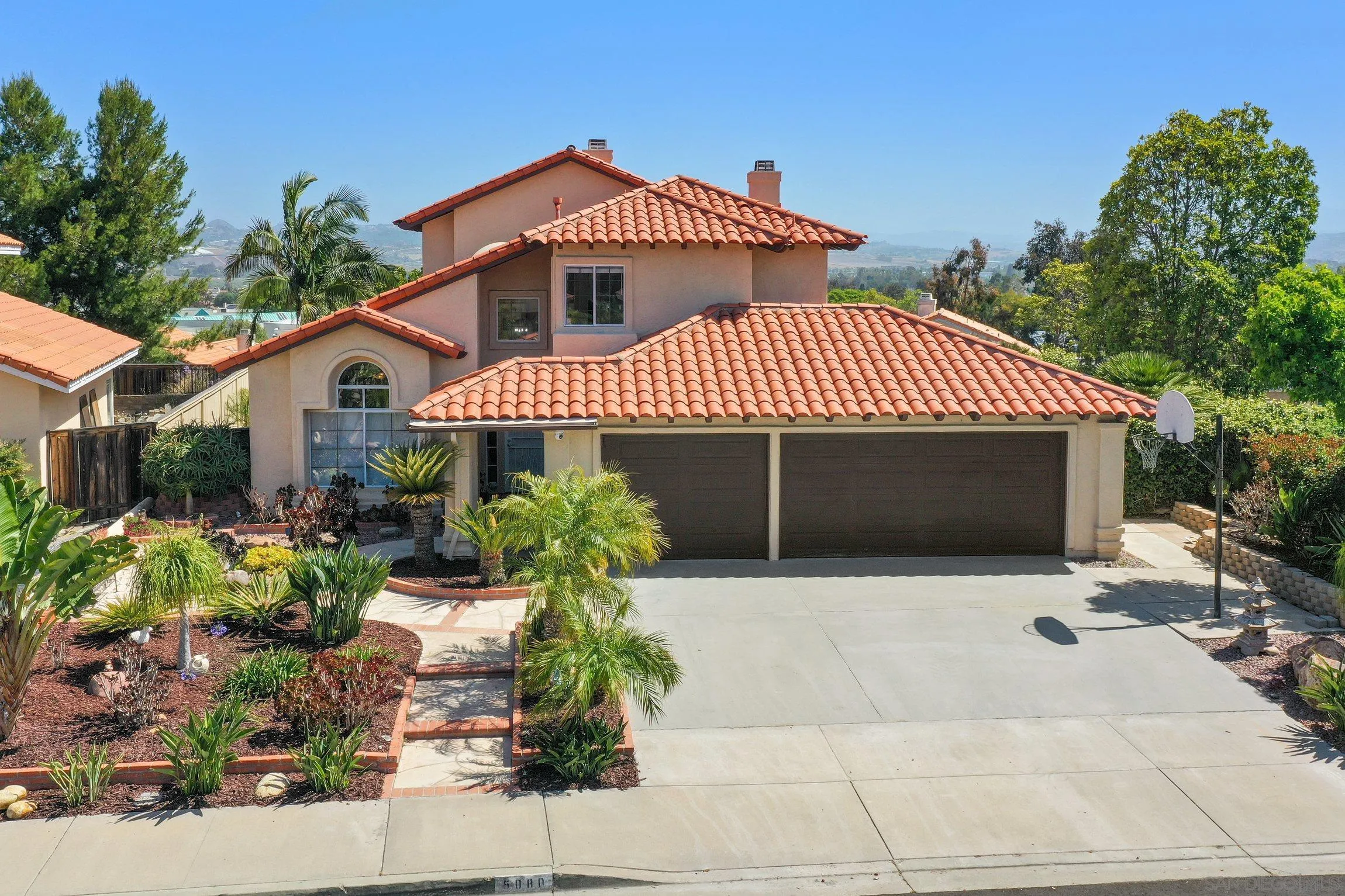 5080 Frazee Road Oceanside, CA 92057 - Photo 6 of 44 a front view of a house with a yard and garage