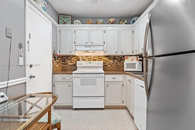 a kitchen with white cabinets and white appliances