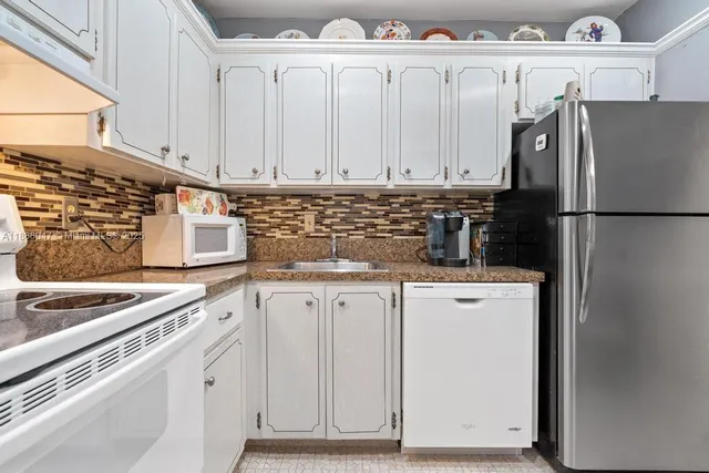 a kitchen with appliances a sink and cabinets