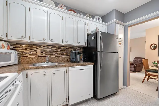a kitchen with granite countertop cabinets and refrigerator