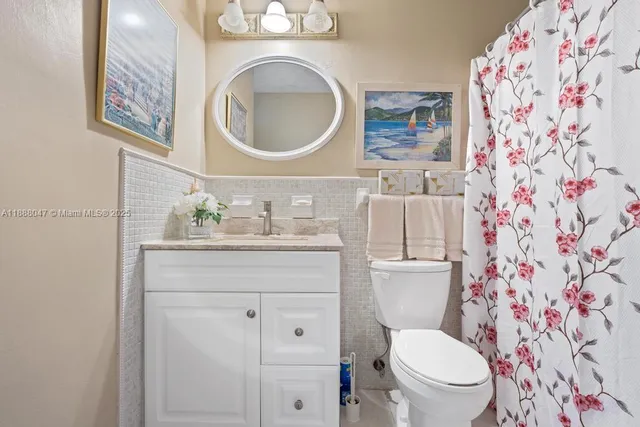 a bathroom with a granite countertop toilet sink and mirror