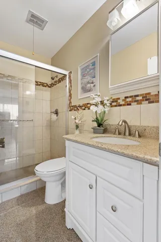 a bathroom with a granite countertop toilet sink and a shower