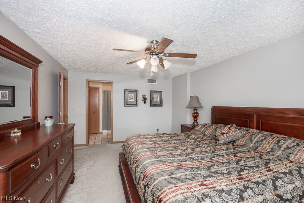 9708 Reed Road Grafton, OH 44044 - Photo 22 of 35 Bedroom featuring light colored carpet, ceiling fan, and a textured ceiling