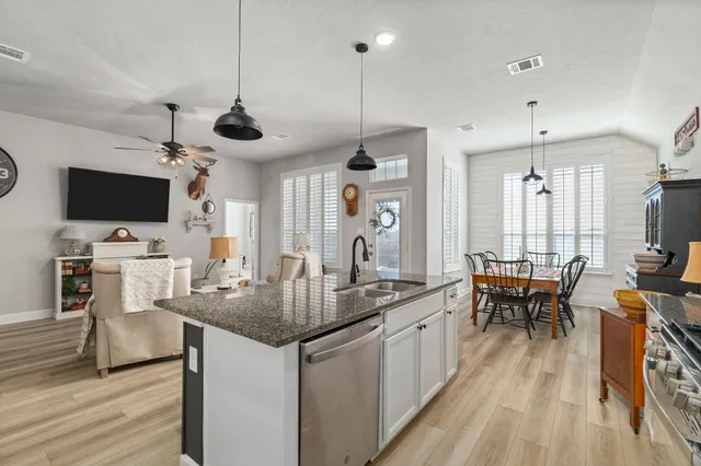 a kitchen with sink cabinets and wooden floor