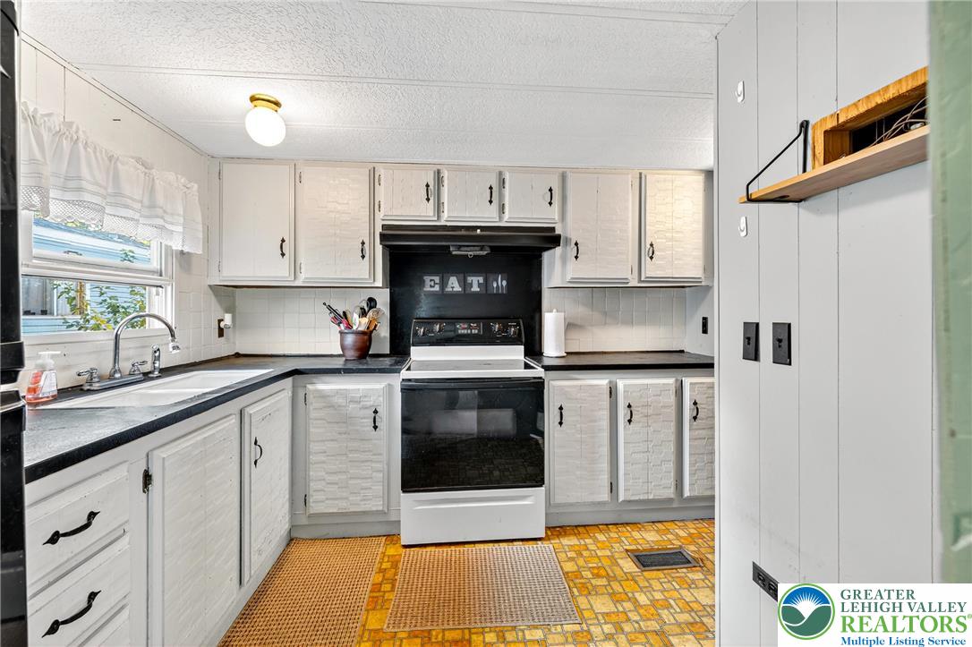 8220 Airport Road, Unit 4 Coatesville, PA 19320 - Photo 8 of 28 a kitchen with stainless steel appliances a stove a sink and a refrigerator