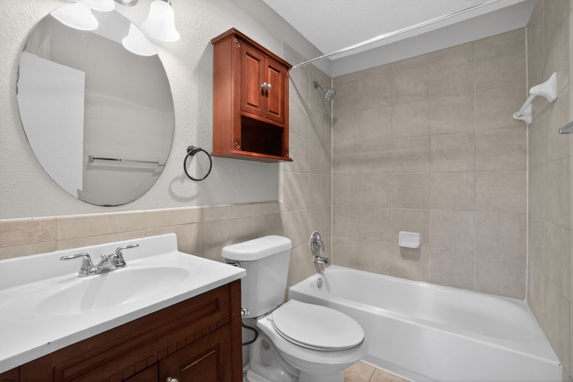 1505 Timber Street Georgetown, TX 78626 - Photo 12 of 22 Bathroom featuring vanity, shower / bath combination, and tile walls