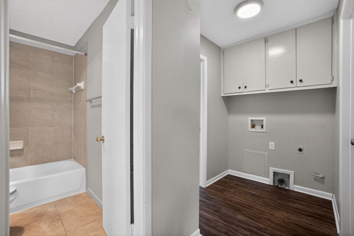 1505 Timber Street Georgetown, TX 78626 - Photo 13 of 22 Laundry area with hookup for a washing machine, hookup for a gas dryer, electric dryer hookup, cabinet space, and dark tile patterned floors