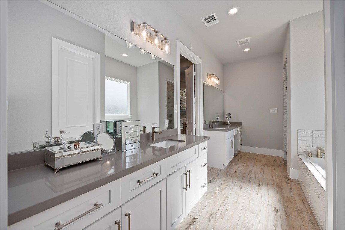 33510 Walnut Crossing Magnolia, TX 77355 - Photo 14 of 50 The ensuite bathroom features dual vanities, a soaking tub, and a separate shower, offering a layout designed for both comfort and efficiency. A space that makes daily routines feel effortless.