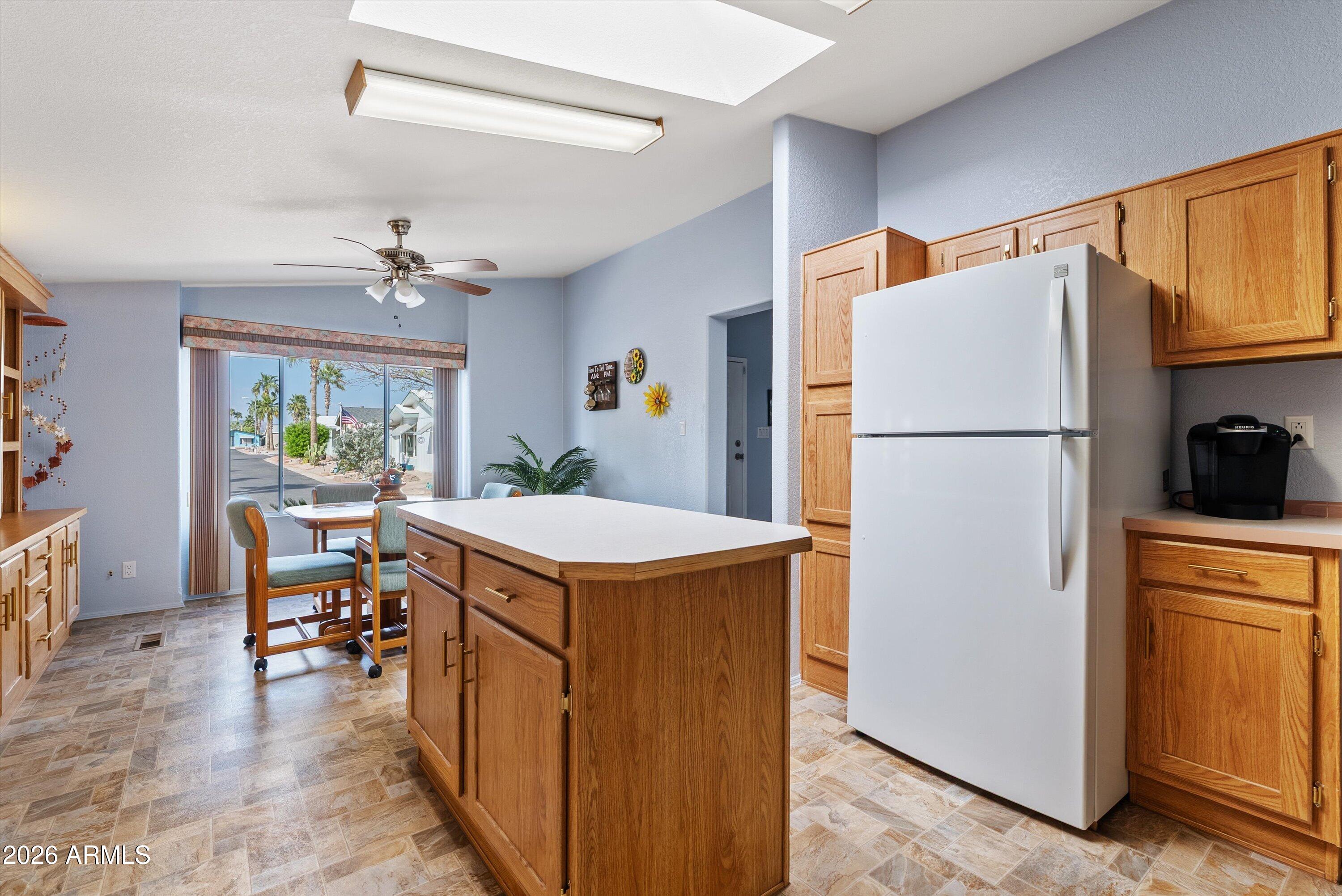 3700 South Tomahawk Road, Unit 91 Apache Junction, AZ 85119 - Photo 5 of 29 a kitchen that has a refrigerator a stove and a dining table in it