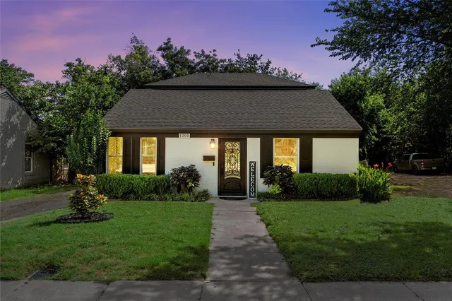 a front view of a house with a yard and trees