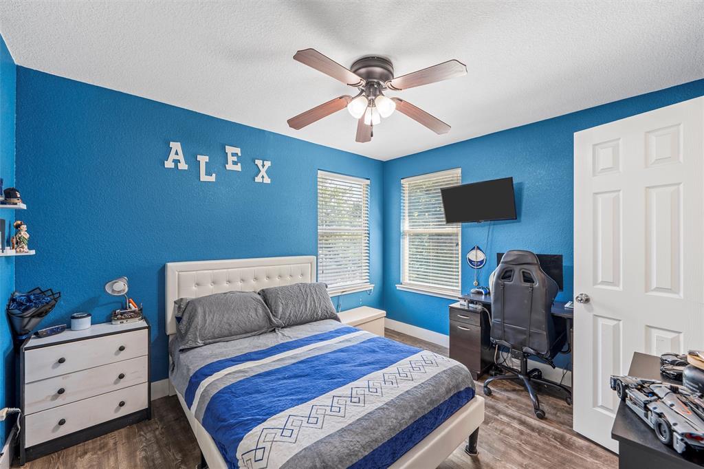 1205 North 17th Street Waco, TX 76707 - Photo 22 of 38 Bedroom with a textured wall, wood finished floors, a textured ceiling, ceiling fan, and a desk