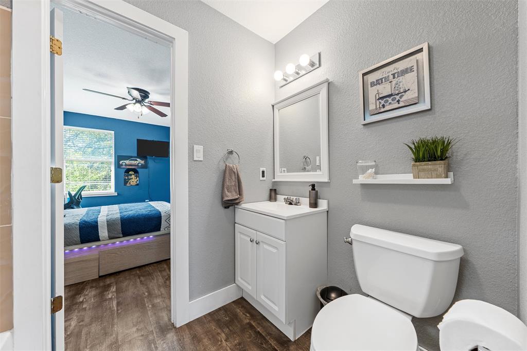 1205 North 17th Street Waco, TX 76707 - Photo 24 of 38 Ensuite bathroom with a textured wall, wood finished floors, vanity, and a ceiling fan
