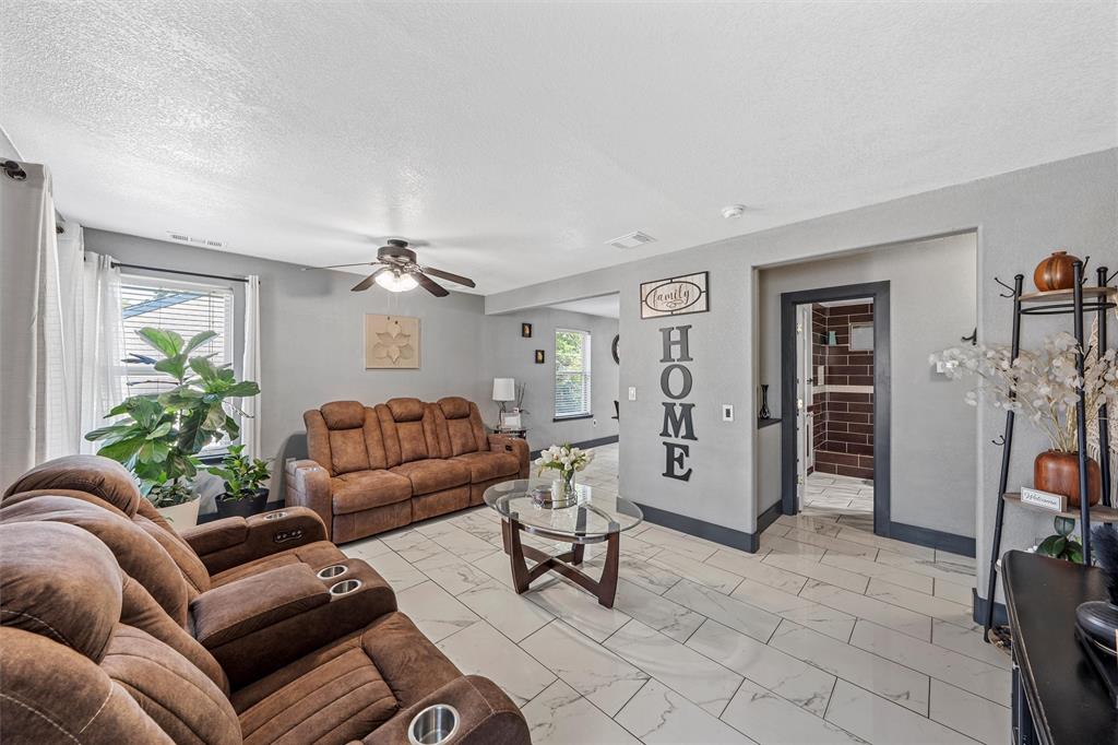 1205 North 17th Street Waco, TX 76707 - Photo 5 of 38 Living room with light marble finish floors, ceiling fan, and a textured ceiling