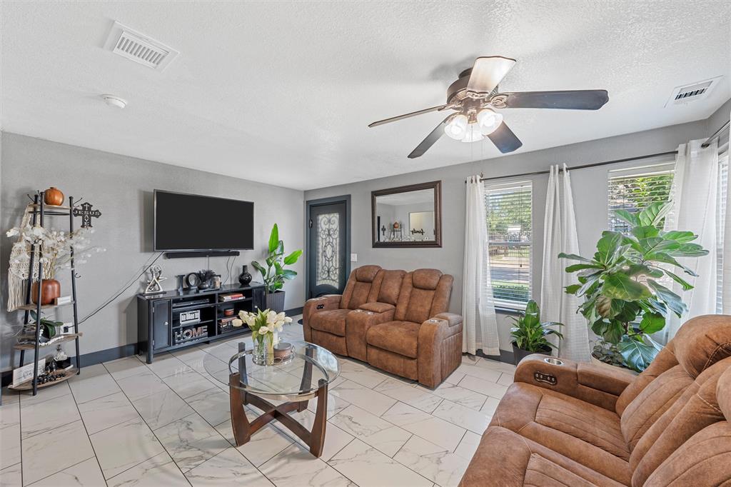 1205 North 17th Street Waco, TX 76707 - Photo 6 of 38 Living area with light marble finish floors, a textured ceiling, and ceiling fan