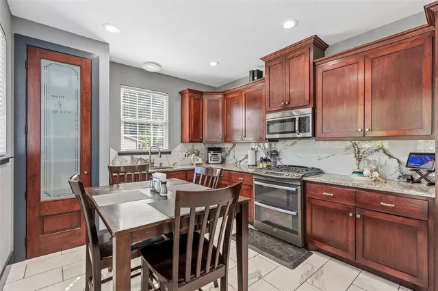 a kitchen with granite countertop a sink stove and cabinets