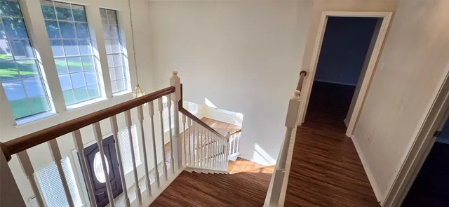 a view of staircase with wooden floor and door