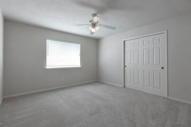 an empty room with fan and windows