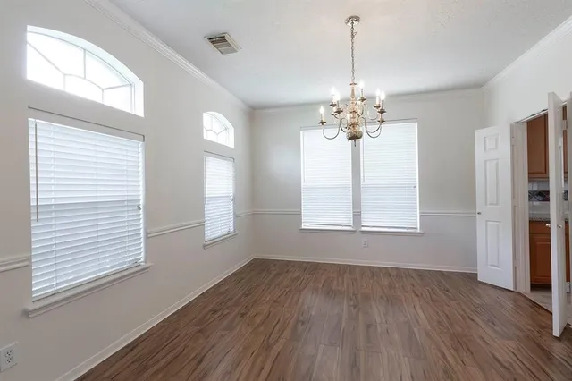 a view of a room with wooden floors and chandelier