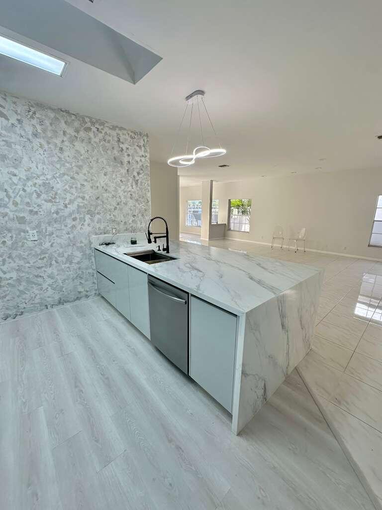 7660 Mansfield Hollow Road Delray Beach, FL 33446 - Photo 12 of 30 a kitchen with stainless steel appliances a sink and cabinets