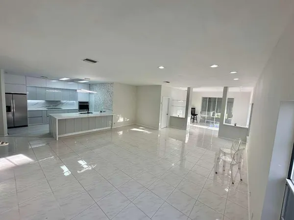 a view of a hallway with wooden floor and windows