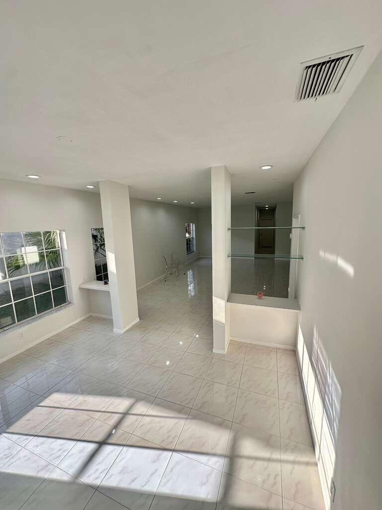 7660 Mansfield Hollow Road Delray Beach, FL 33446 - Photo 16 of 30 a view of a hallway with wooden floor and windows