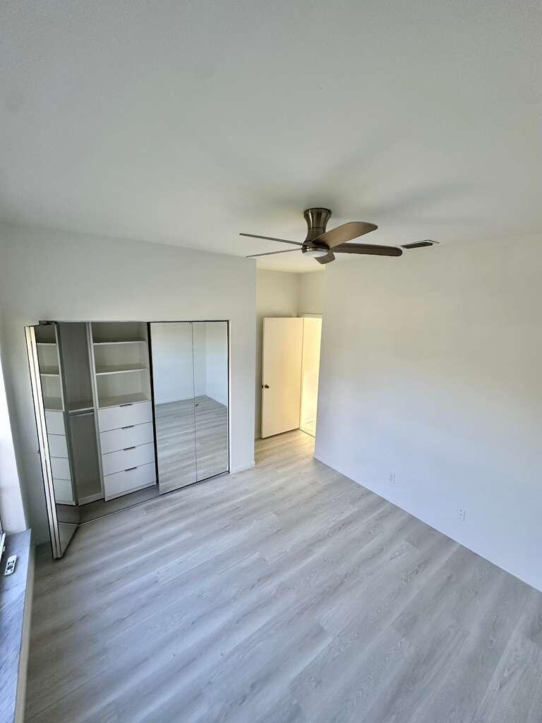 7660 Mansfield Hollow Road Delray Beach, FL 33446 - Photo 25 of 30 an empty room with wooden floor closet and windows