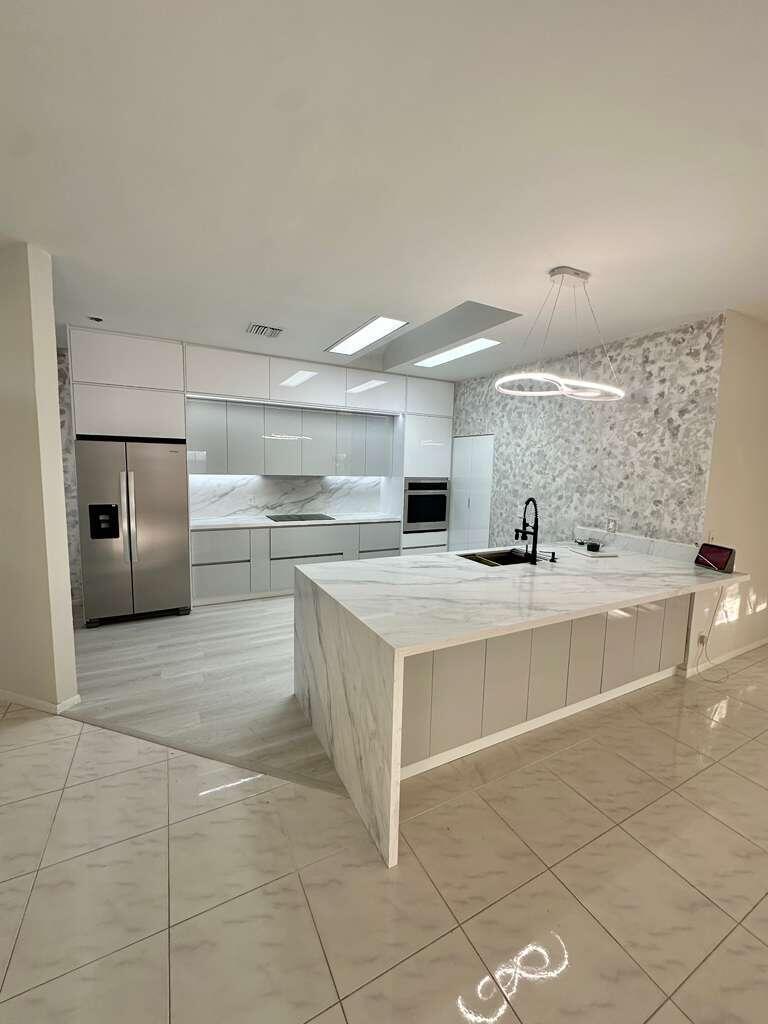 7660 Mansfield Hollow Road Delray Beach, FL 33446 - Photo 7 of 30 a large kitchen with kitchen island a sink stainless steel appliances and cabinets