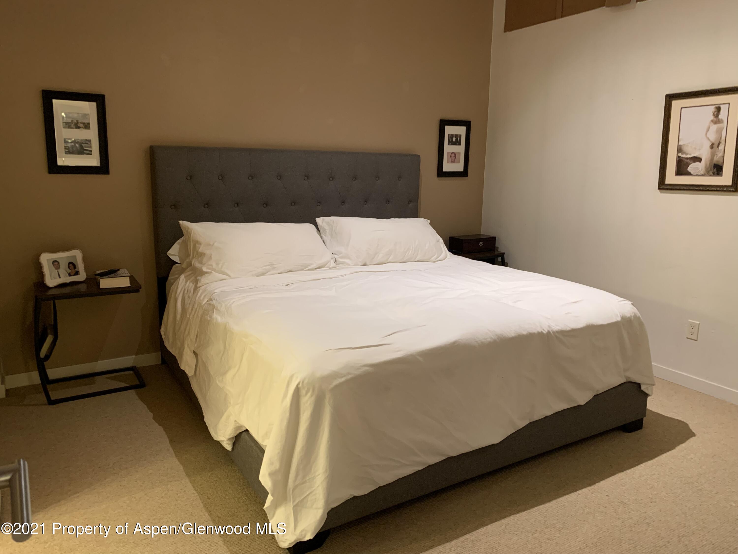 231 Robinson Street, Unit R302 Basalt, CO 81621 - Photo 16 of 31 a large bed sitting in a bedroom and a lamp