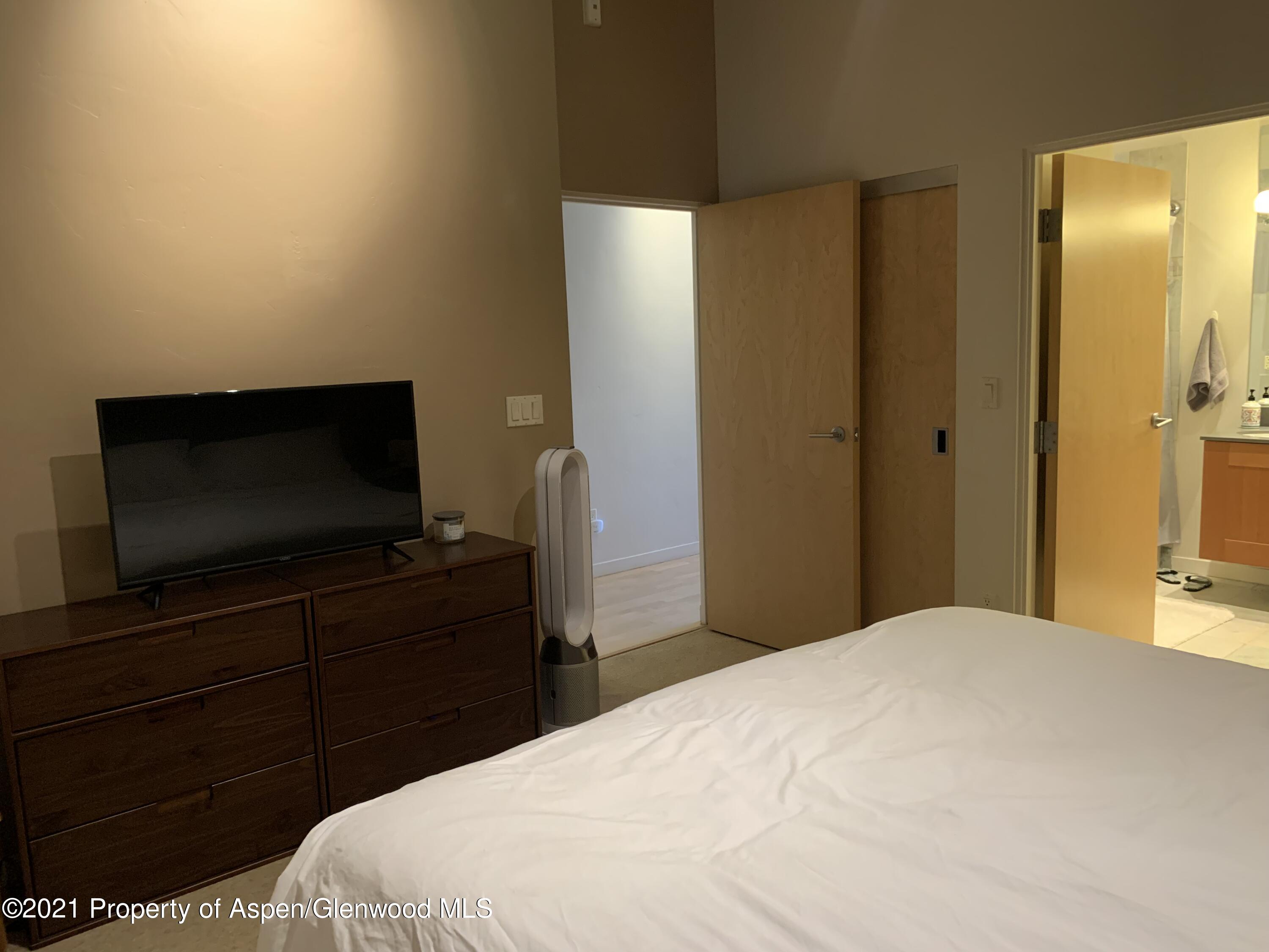 231 Robinson Street, Unit R302 Basalt, CO 81621 - Photo 17 of 31 a bedroom with a bed and a flat screen tv