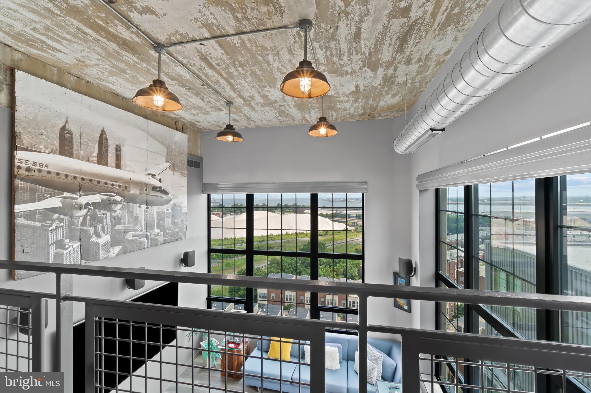 1200 Steuart Street, Unit 1119 Baltimore, MD 21230 - Photo 16 of 37 a view of a dining room with furniture large windows and wooden floor