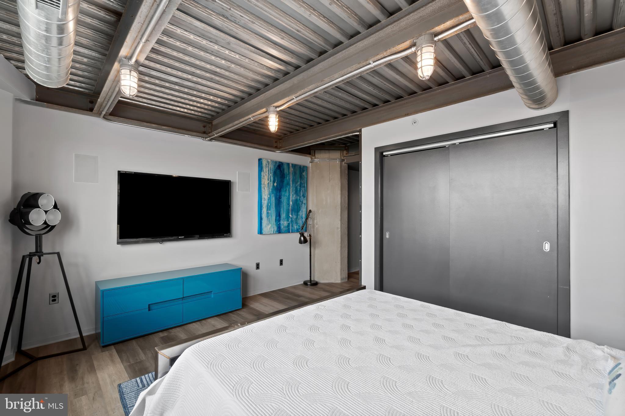 1200 Steuart Street, Unit 1119 Baltimore, MD 21230 - Photo 22 of 37 a bedroom with a bed and a flat screen tv