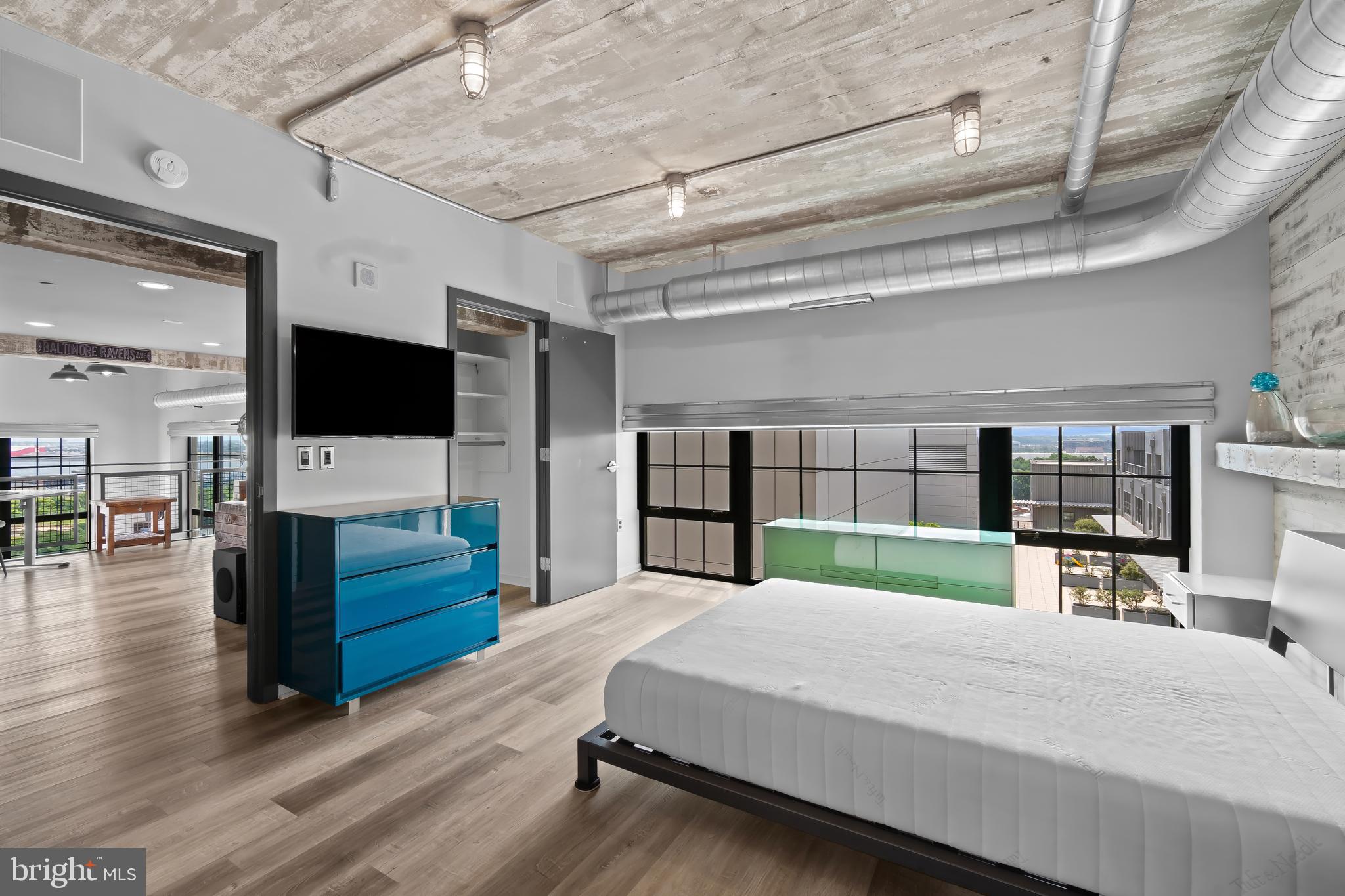 1200 Steuart Street, Unit 1119 Baltimore, MD 21230 - Photo 26 of 37 a bed room with furniture and a flat screen tv