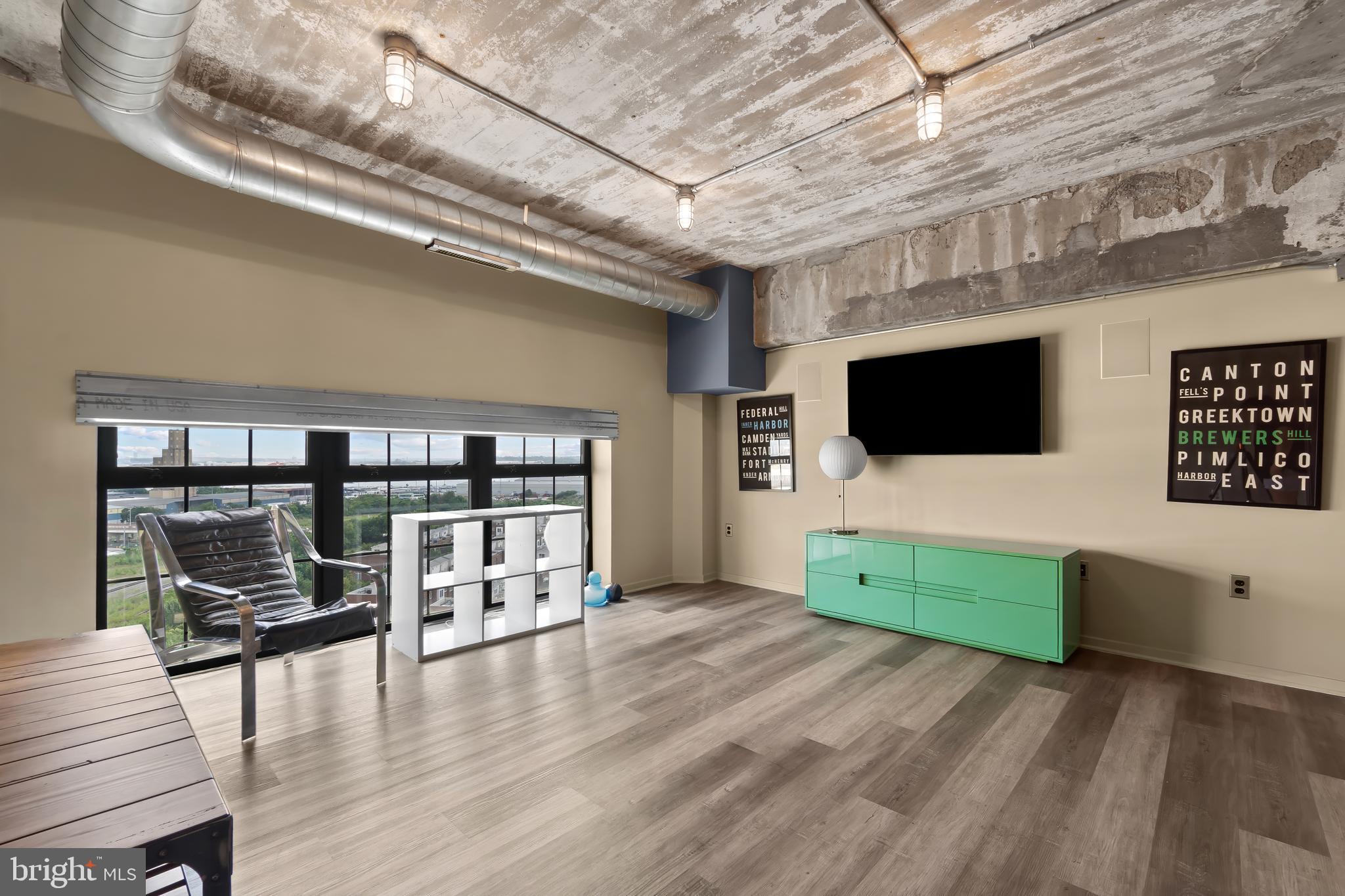 1200 Steuart Street, Unit 1119 Baltimore, MD 21230 - Photo 28 of 37 a living room with furniture and a flat screen tv