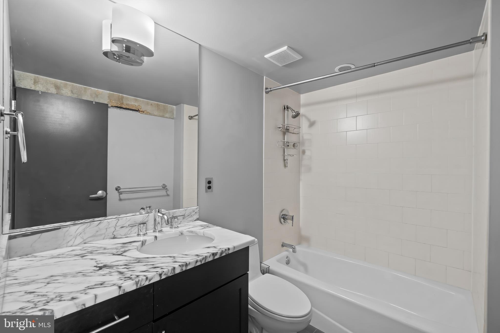 1200 Steuart Street, Unit 1119 Baltimore, MD 21230 - Photo 32 of 37 a bathroom with a granite countertop sink toilet and shower