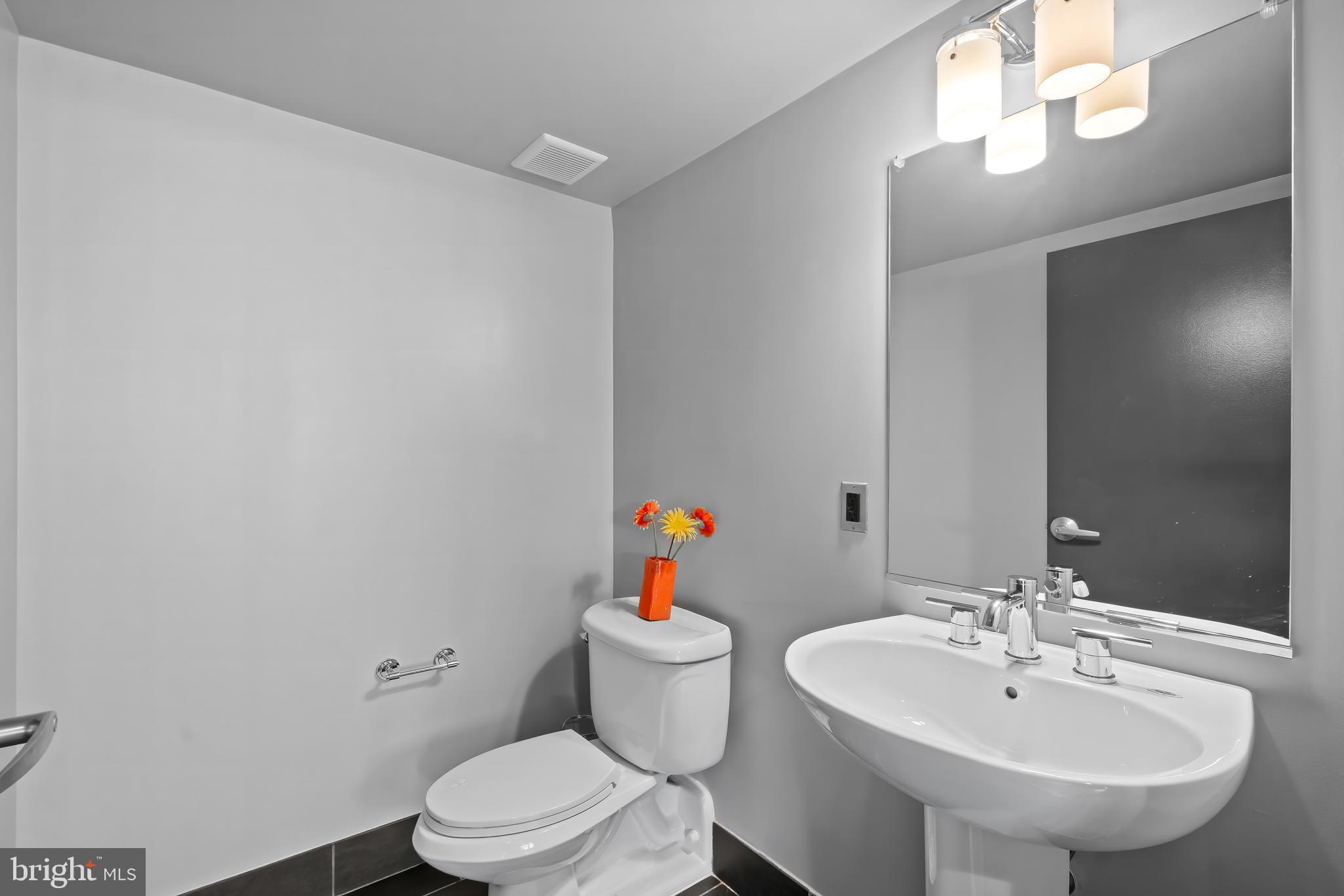 1200 Steuart Street, Unit 1119 Baltimore, MD 21230 - Photo 33 of 37 a bathroom with a sink a toilet and a mirror