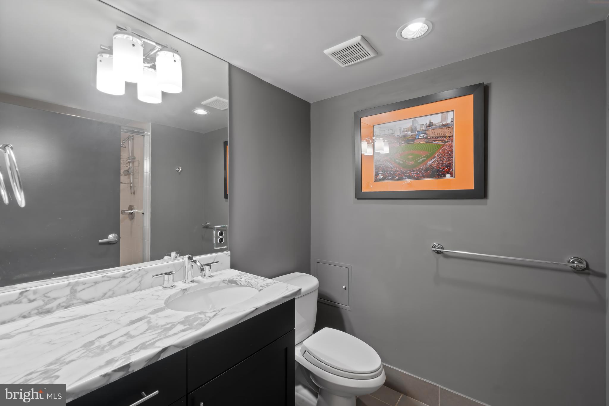 1200 Steuart Street, Unit 1119 Baltimore, MD 21230 - Photo 34 of 37 a bathroom with a granite countertop sink mirror vanity and toilet