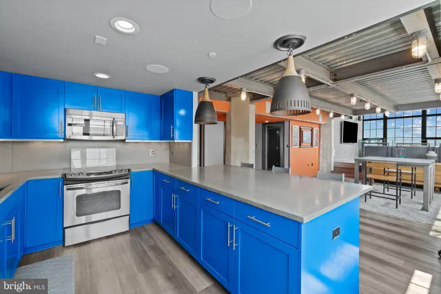 a kitchen with stainless steel appliances granite countertop a kitchen island a table and chairs