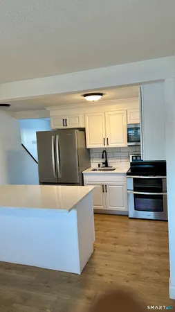 a kitchen with stainless steel appliances a stove a sink and a refrigerator