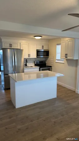 a kitchen with stainless steel appliances a refrigerator and a stove top oven
