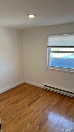 a view of an empty room and wooden floor