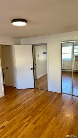 an empty room with wooden floor and mirror