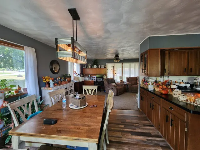 a view of a dining room and livingroom with furniture wooden floor a chandelier