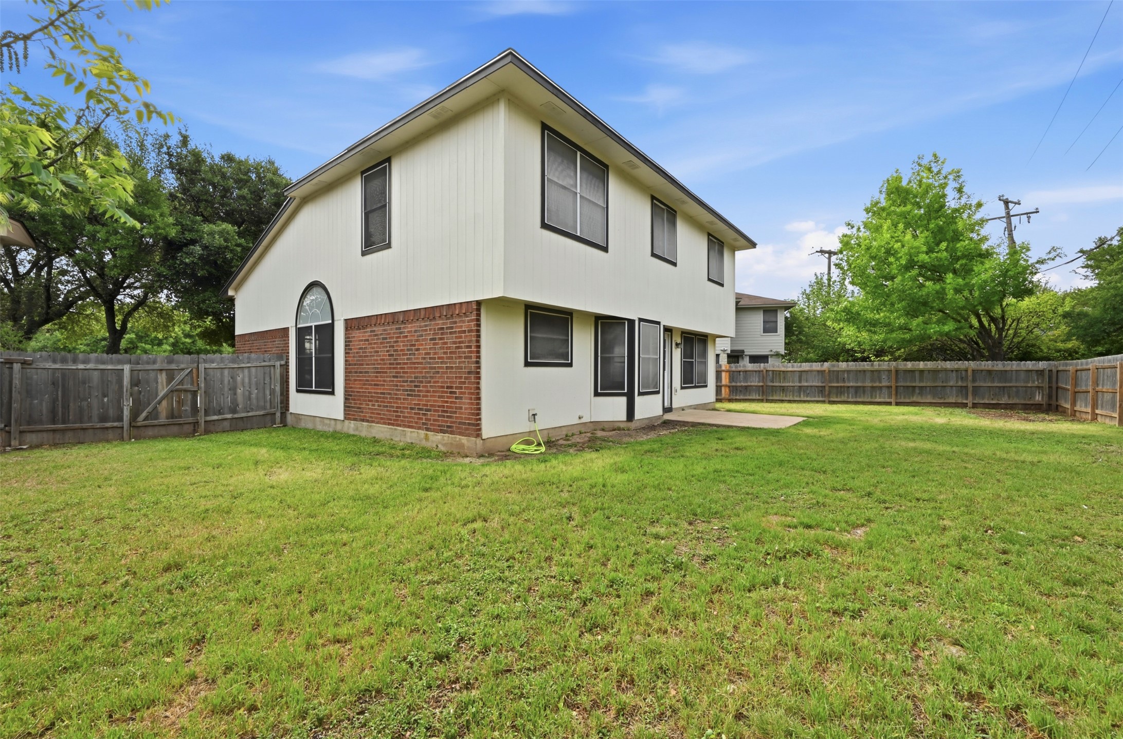 3629 Ruby Red Drive Austin, TX 78728 - Photo 31 of 35 Rear view of house with brick siding, first of two gates, and window screens