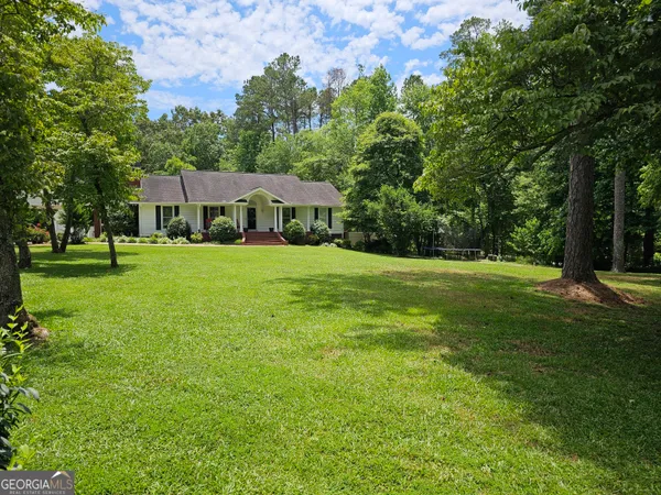 a front view of a house with yard and green space