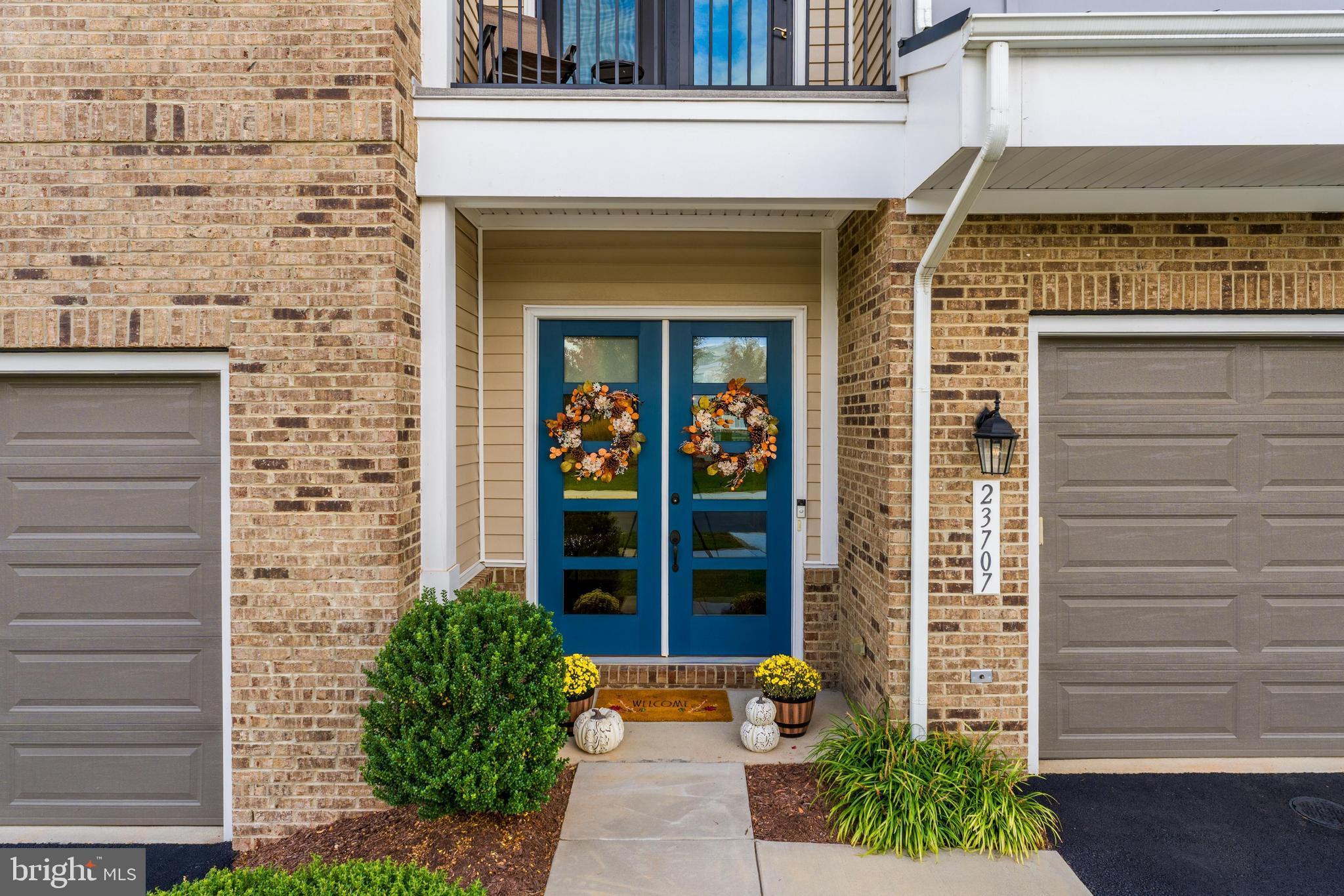 23707 Kinston Ferry Terrace Ashburn, VA 20148 - Photo 2 of 42 a front view of a house with a potted plant and garage