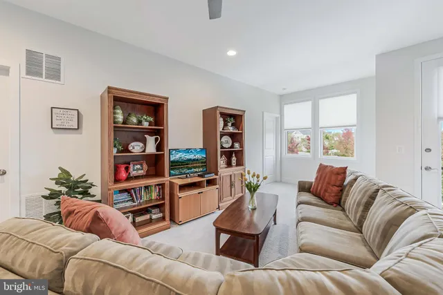 a living room with furniture and a book shelf