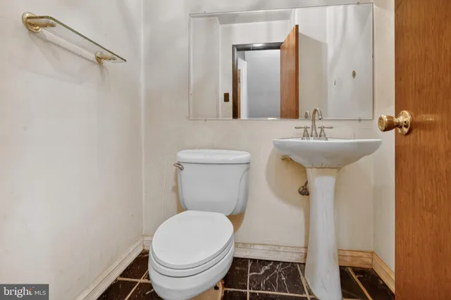 a bathroom with a sink toilet and a mirror