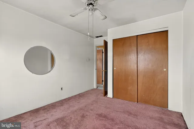 a view of a room with a mirror and a ceiling fan