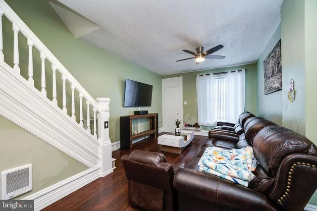 a living room with furniture ceiling fan and a window